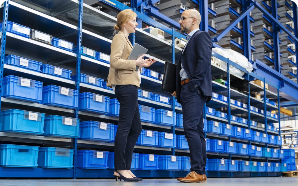 Geschäftsmann und Geschäftsfrau im Gespräch in einer Lagerhalle
