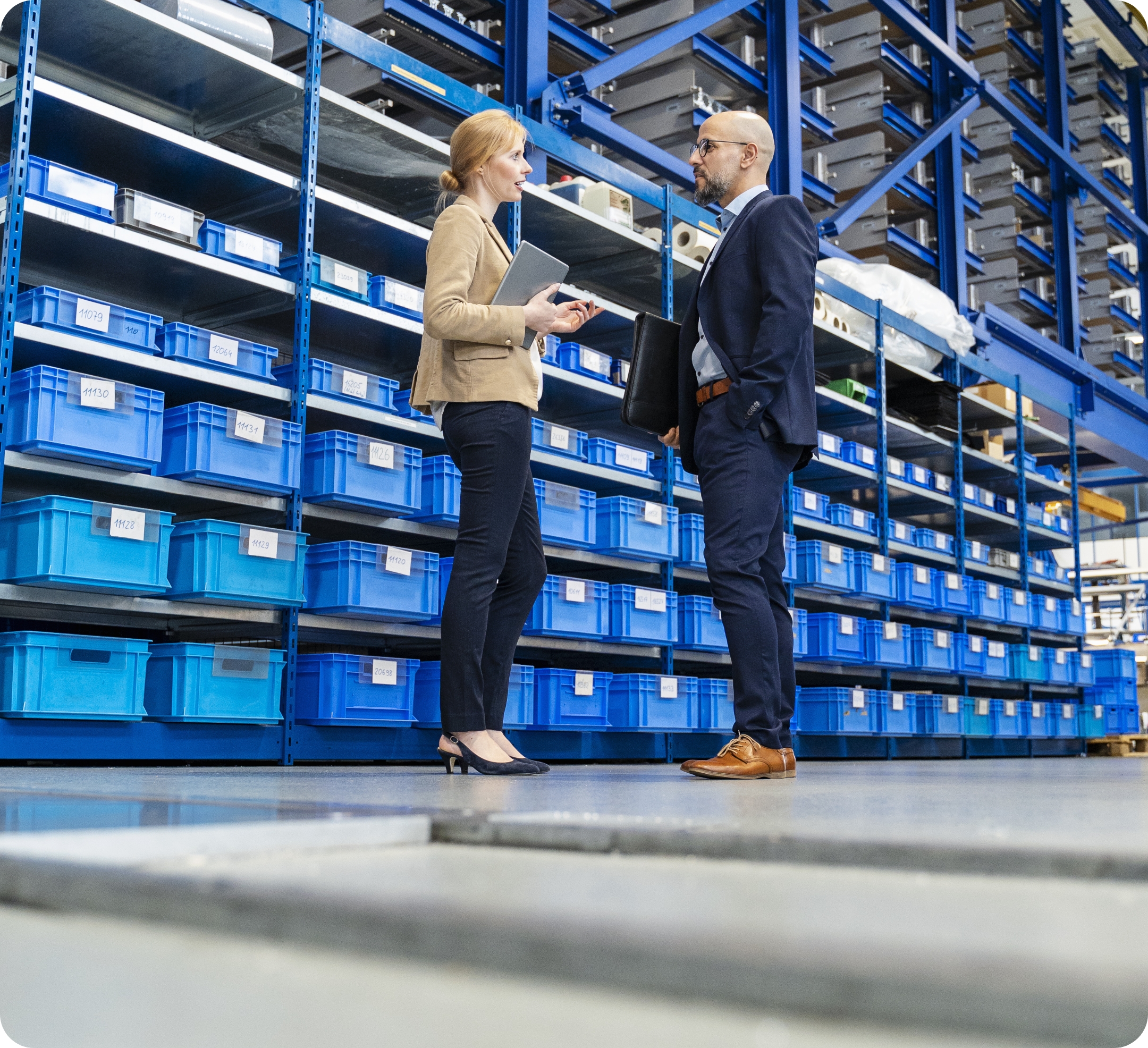 Geschäftsmann und Geschäftsfrau im Gespräch in einer Lagerhalle
